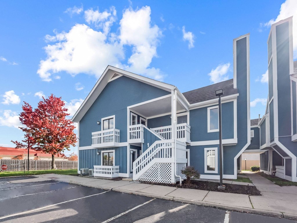 a blue house with stairs and a street in front of it