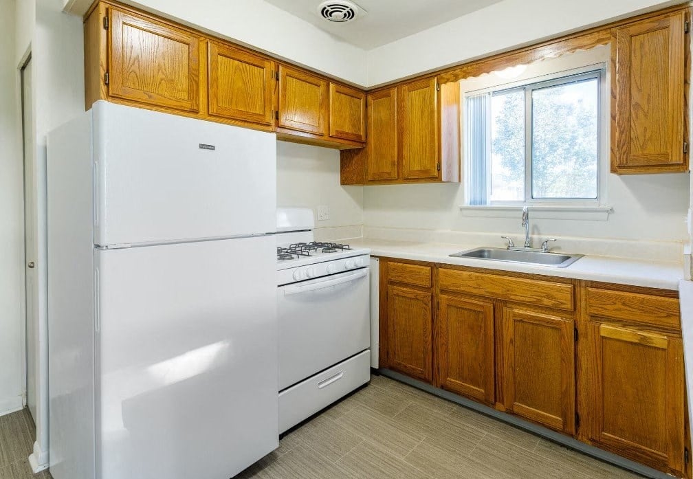 a kitchen with white appliances and wooden cabinets