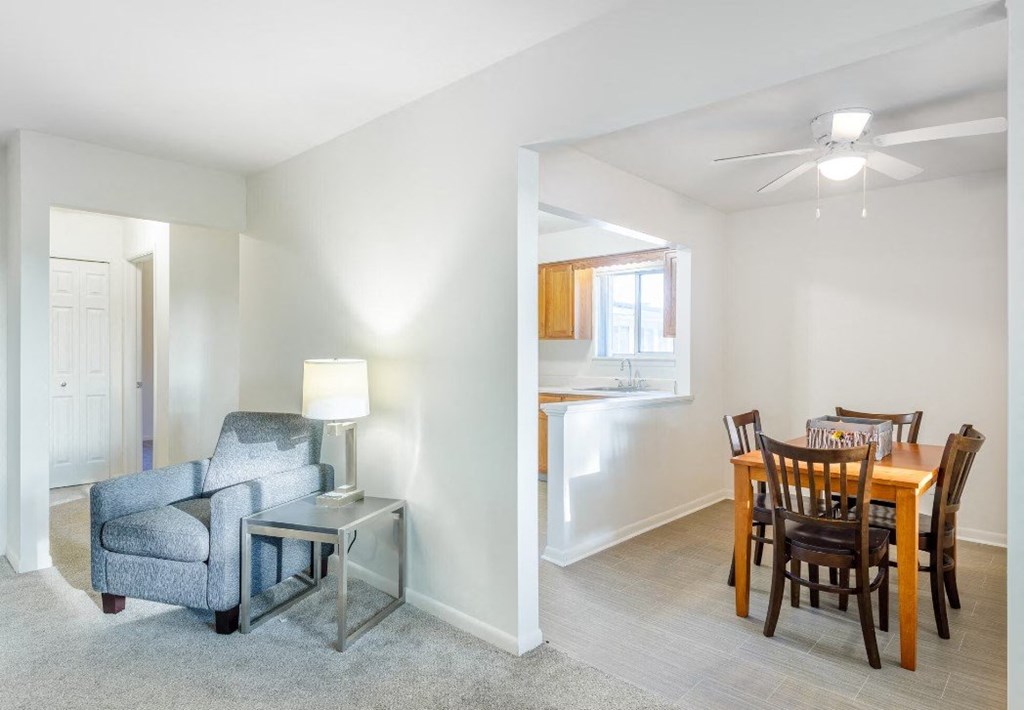 a living room and a dining room with a table and chairs