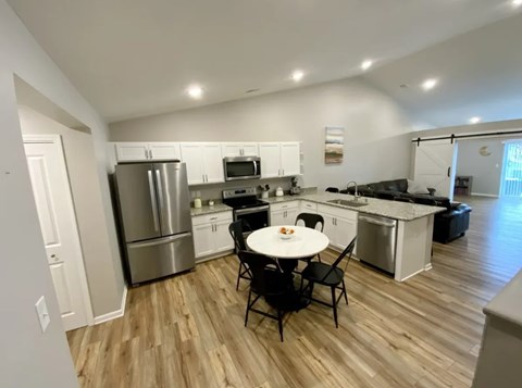 A kitchen with a table and chairs in the middle of the room.