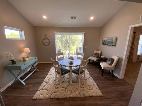 A dining room with a table and chairs.
