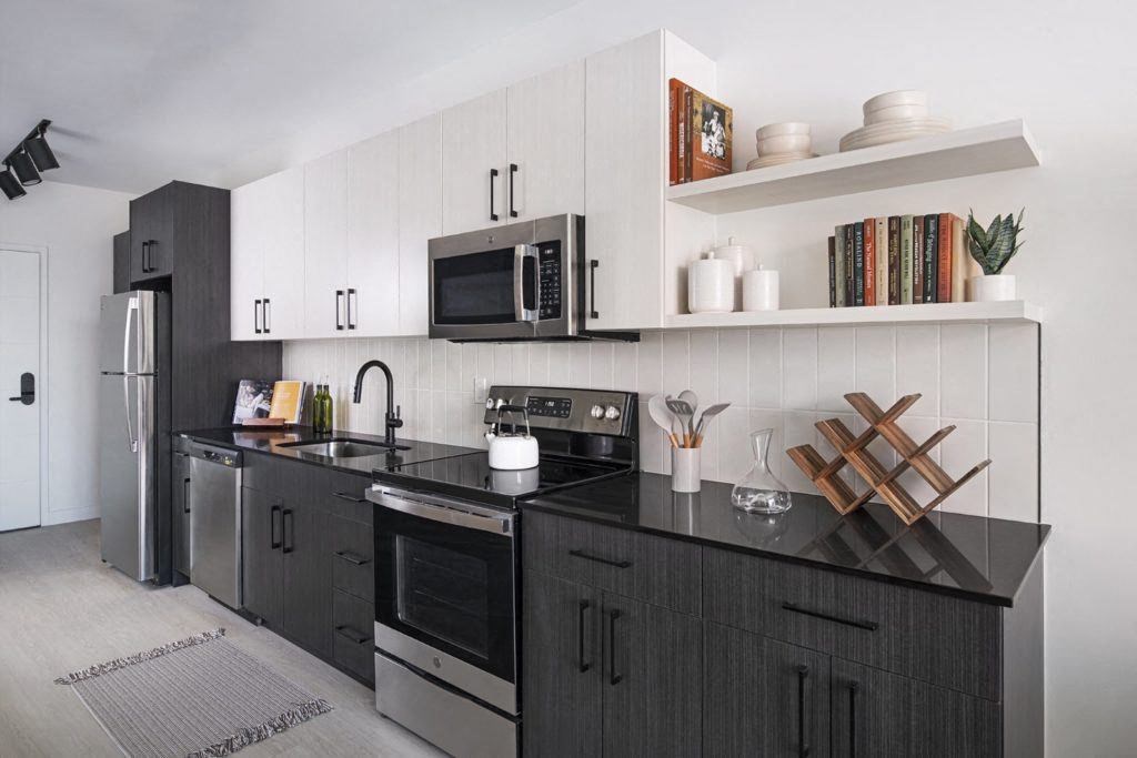 a black and white kitchen with a microwave and a sink