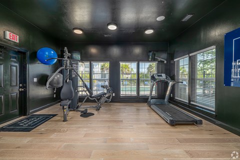 A gym with treadmills, exercise bikes, and a weight machine.