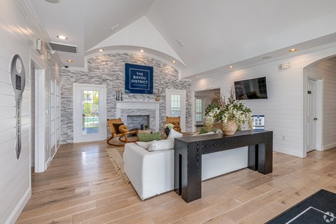 A living room with a stone fireplace and a flat screen TV mounted on the wall.