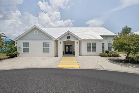 A building with a grey roof and white walls with a yellow line in front.