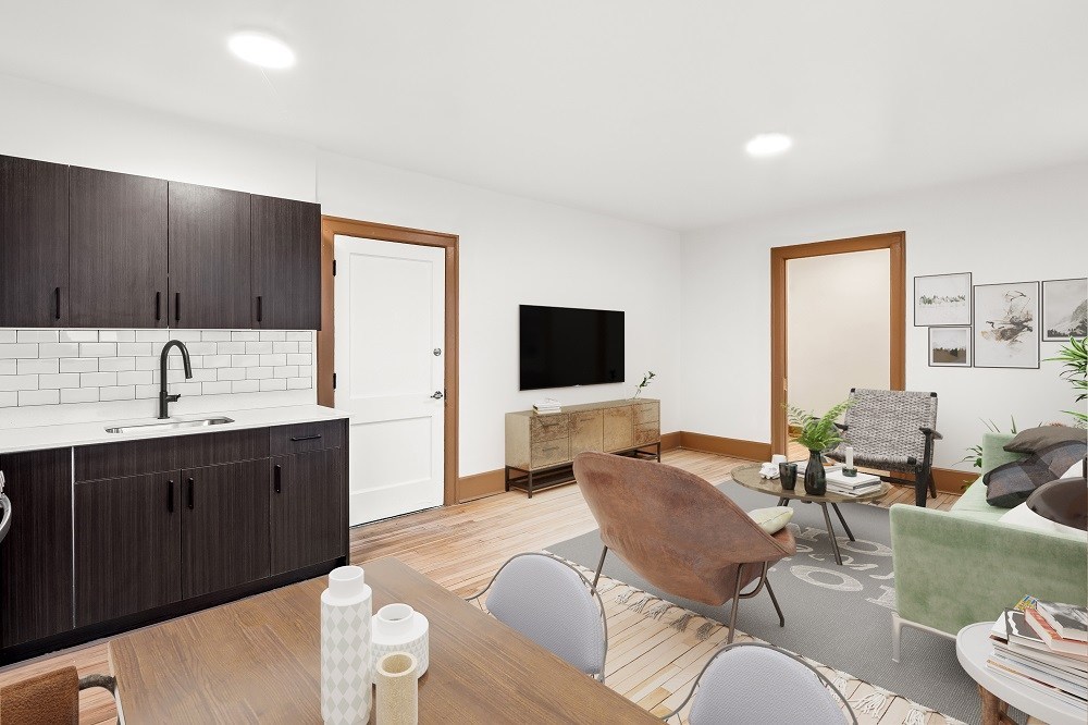A modern kitchen with dark wood cabinets and a white backsplash.