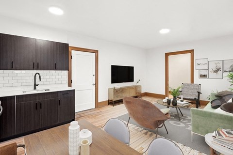 A modern kitchen with dark wood cabinets and a white backsplash.