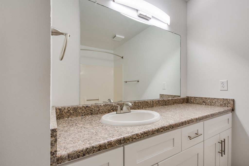 A bathroom with a sink and a mirror.