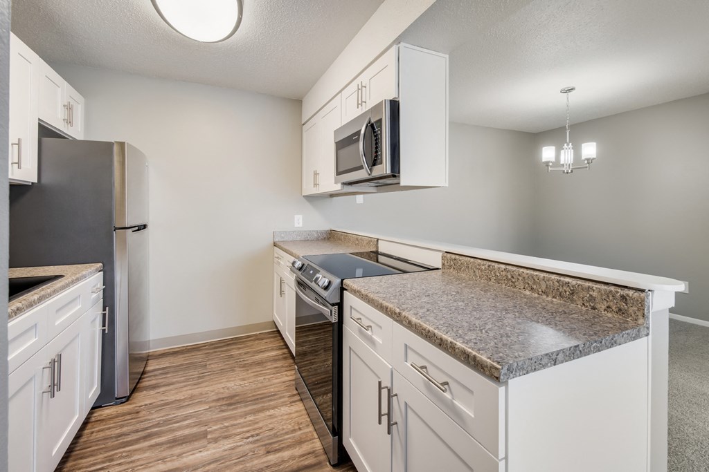 A kitchen with a granite countertop and stainless steel appliances.
