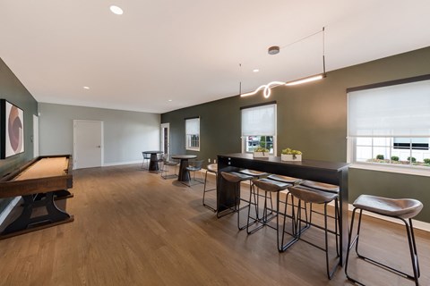 A modern bar area with a pool table and stools.