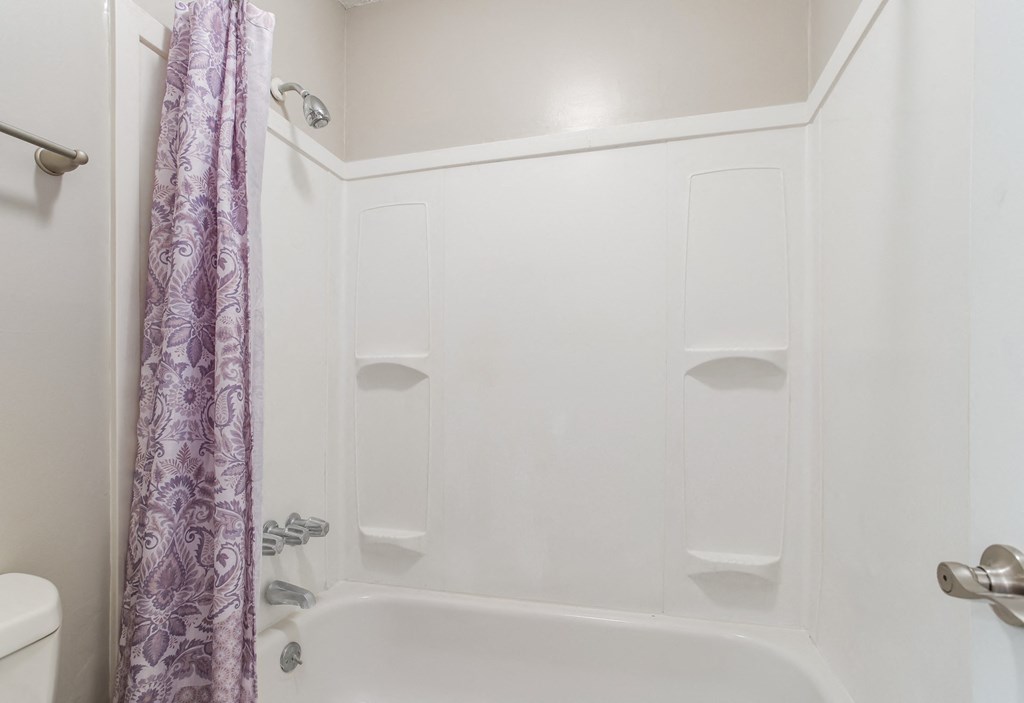 a white bathroom with a shower and a toilet