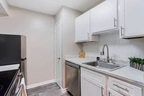 a kitchen with white cabinets and stainless steel appliances and a sink