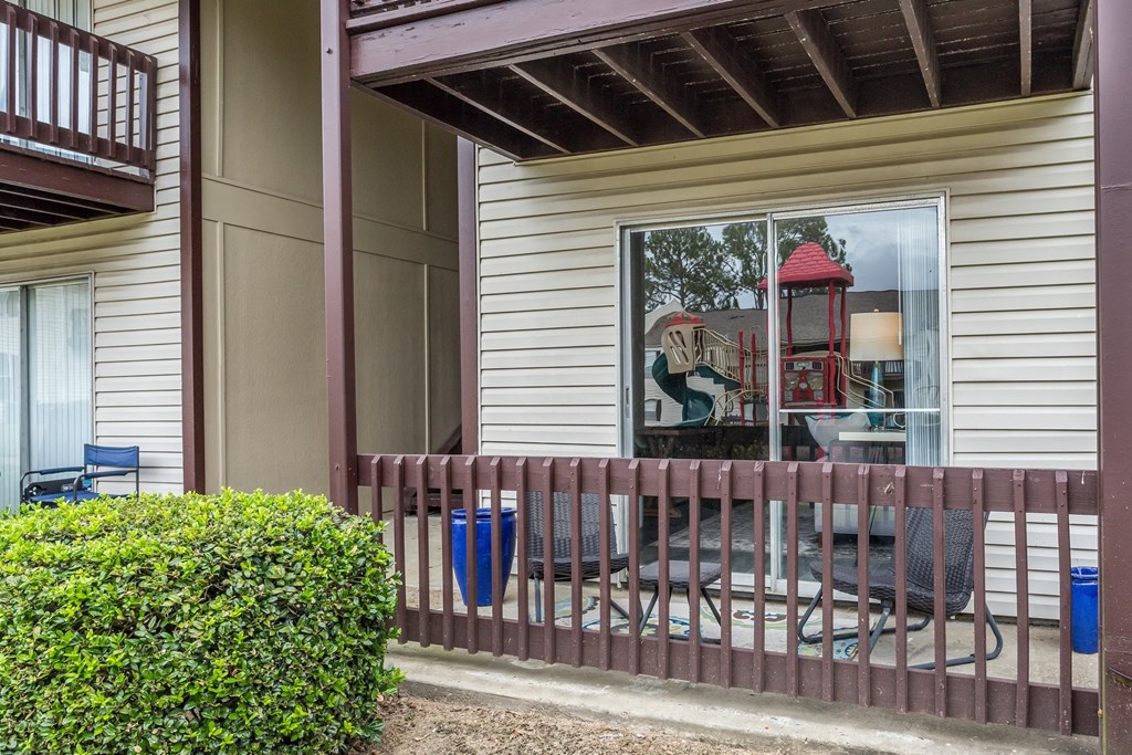 a porch with chairs and a sliding glass window