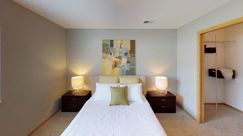 A bedroom with a large bed and two lamps on side tables.