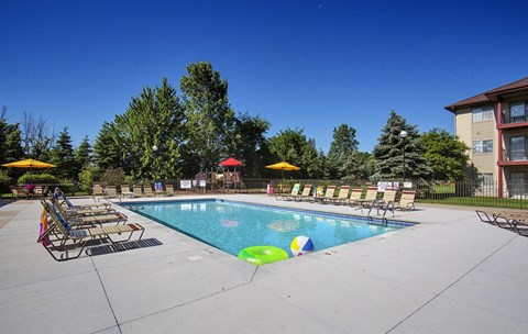 A swimming pool with a few chairs around it.