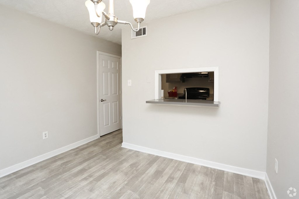 an empty living room with a white wall and a white door