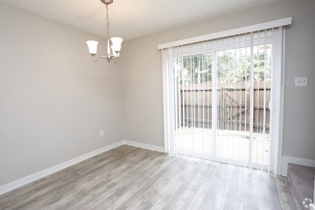 an empty living room with a sliding glass door to a patio