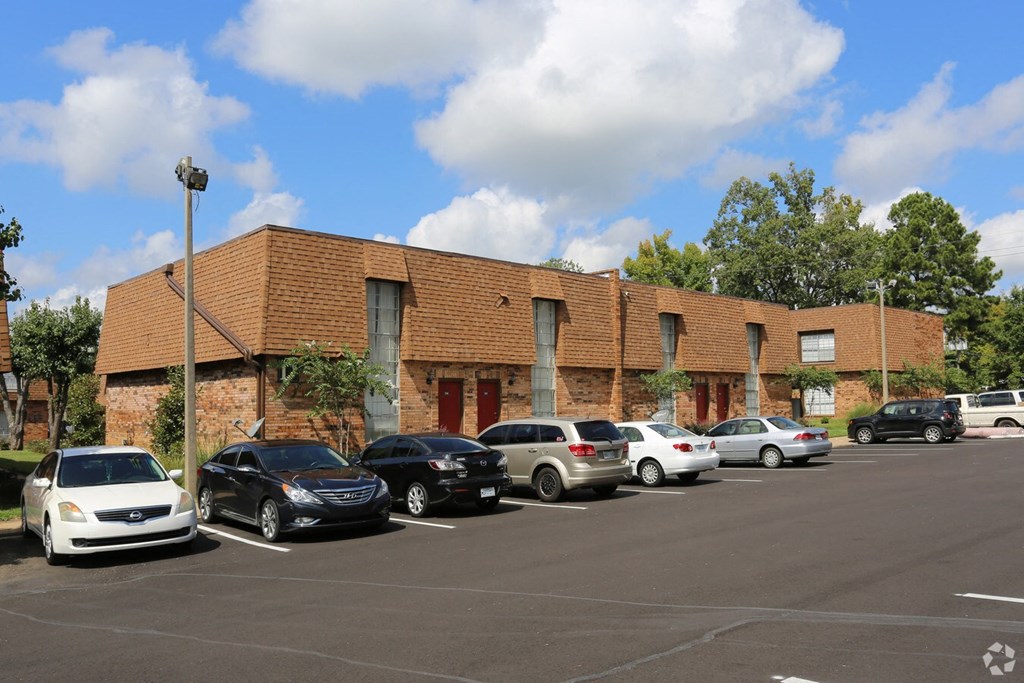a brick building with a parking lot full of cars