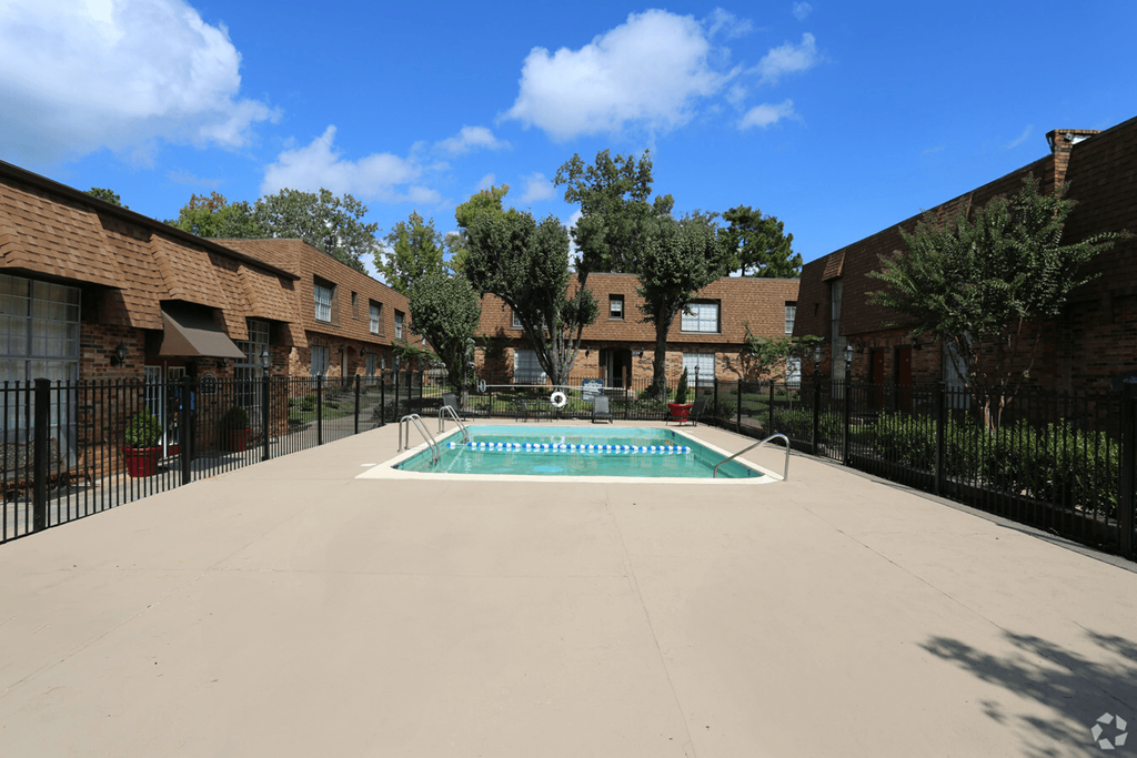 A pool in the middle of a courtyard surrounded by buildings.