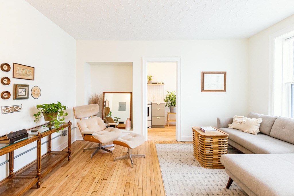 a living room with a couch and a chair and a mirror