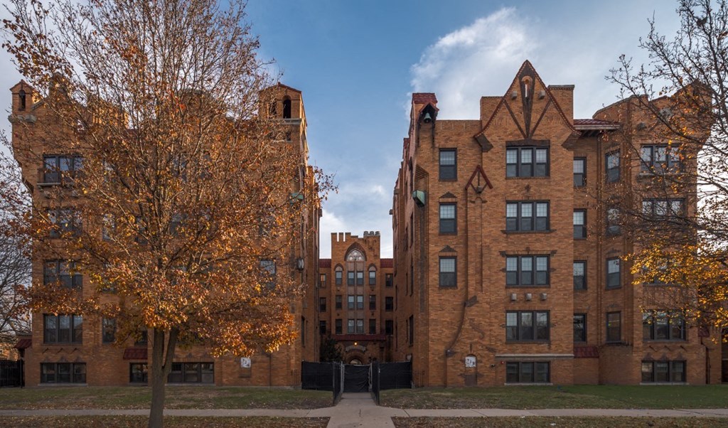 an old brick building with a tree in front of it