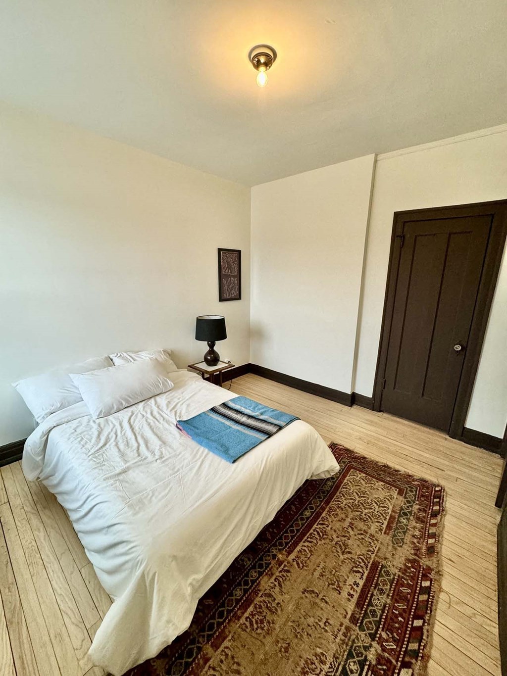 a bedroom with a bed and a rug