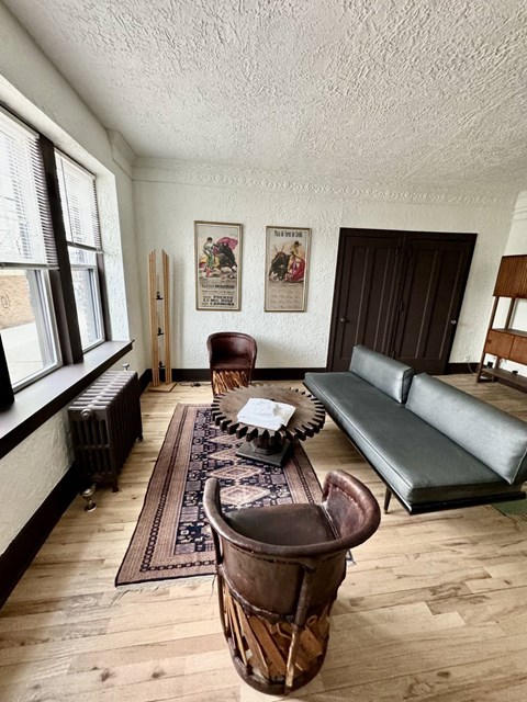 A living room with a brown leather couch and a wooden table.