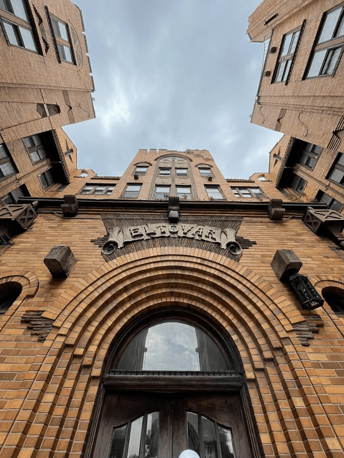 an archway of a brick building with a sky background