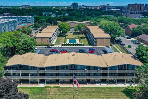 an aerial view of a building with a brown roof and a city in the background