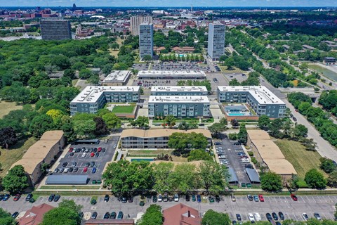 an aerial view of a city with cars in a parking lot
