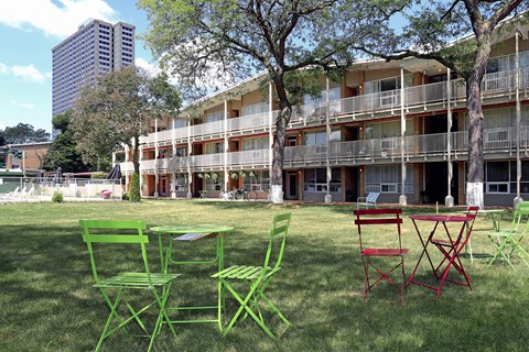 a group of chairs and tables in front of an apartment building