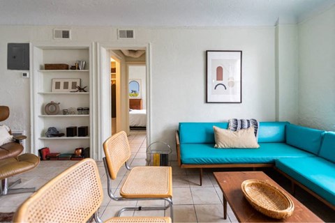 A living room with a blue couch and a wooden coffee table.