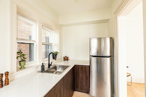 a kitchen with a sink and a stainless steel refrigerator
