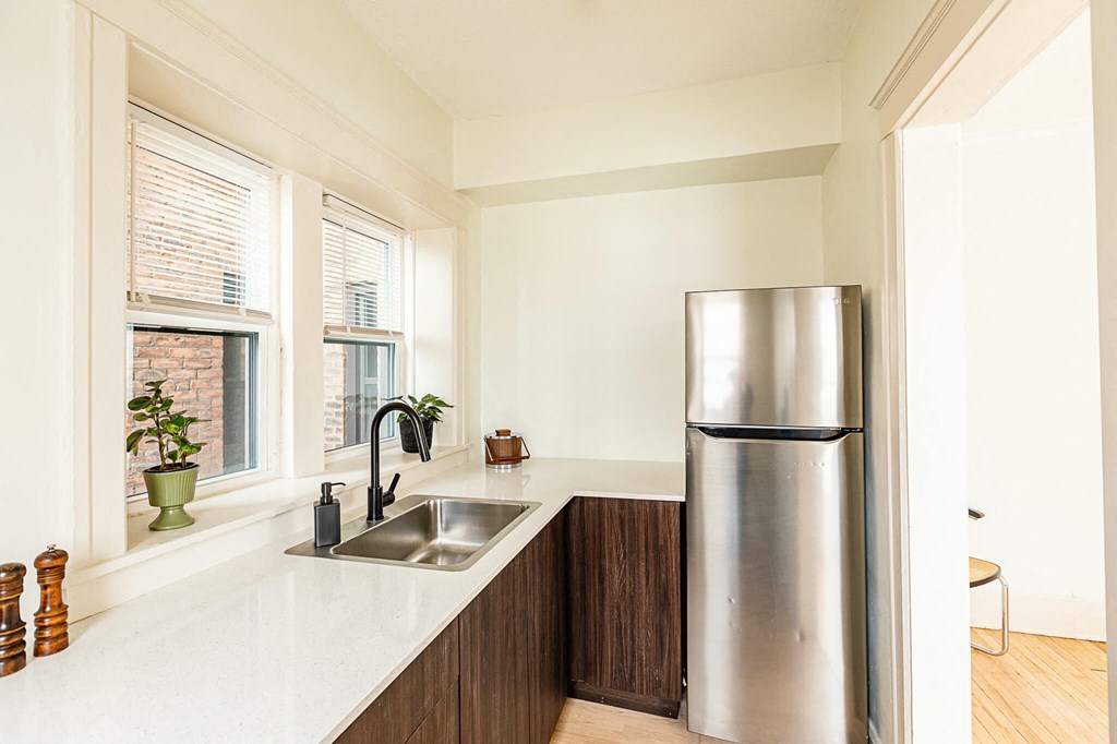 a kitchen with a stainless steel refrigerator and a sink