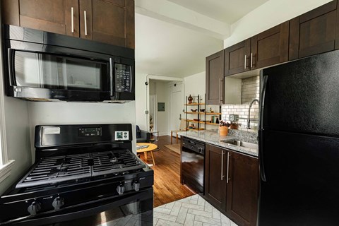 a kitchen with a stove and a microwave and a sink