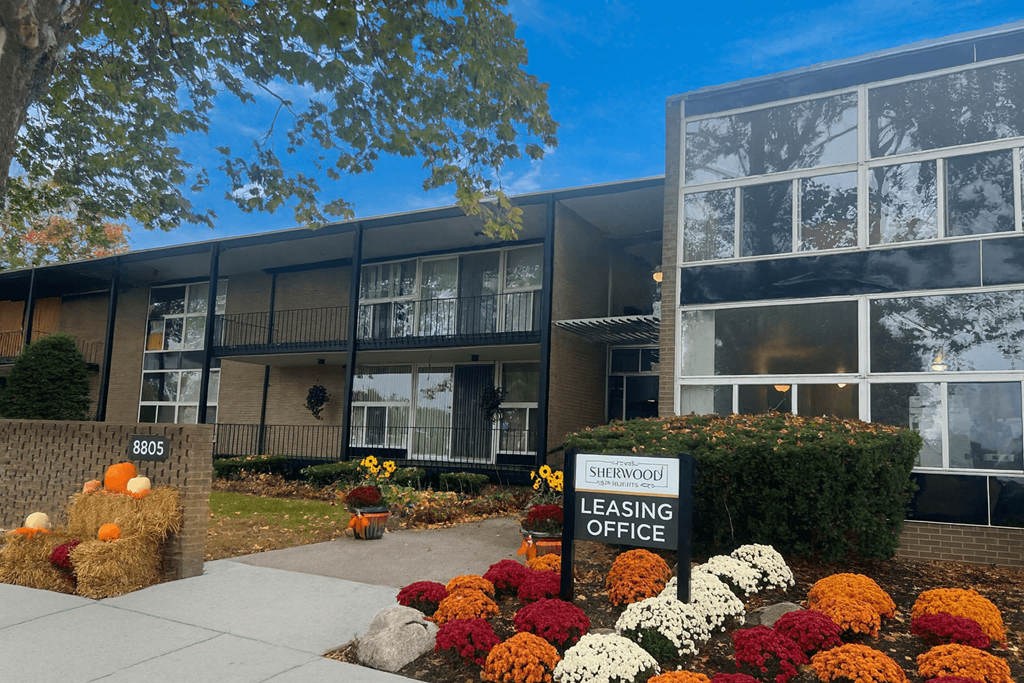 A leasing office sign is in front of a building.