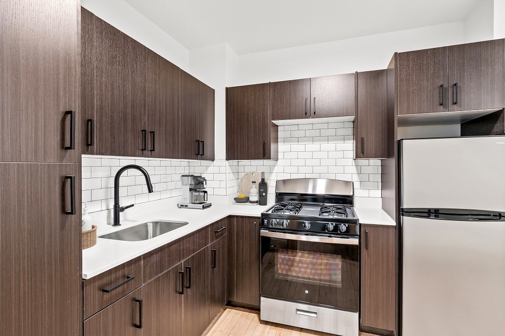 A kitchen with brown cabinets and stainless steel appliances.