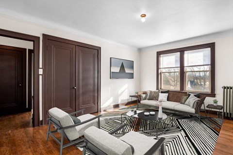 A living room with a black and white striped rug and a grey sofa.