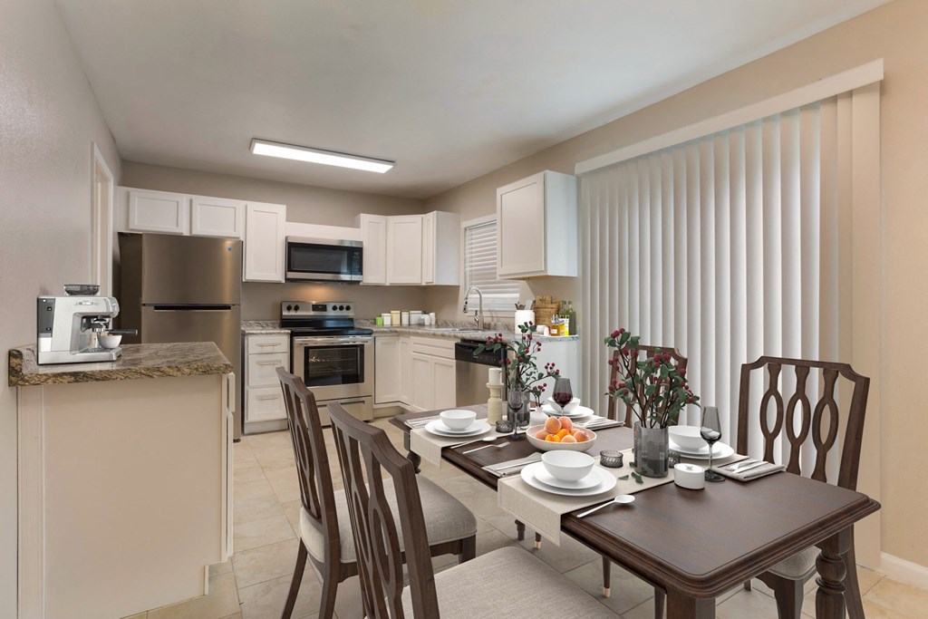 a kitchen with a table and chairs in front of a window