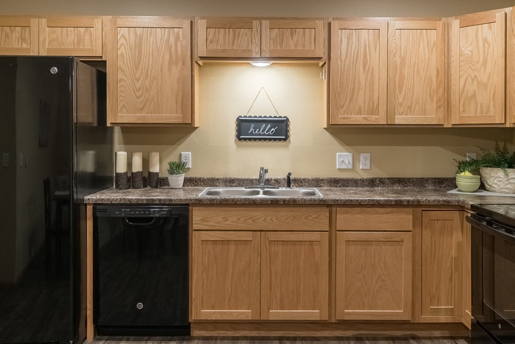 a kitchen with wooden cabinets and a sink and a refrigerator
