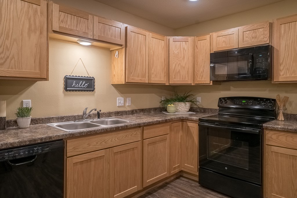 a kitchen with black appliances and wooden cabinets