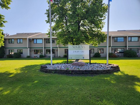 A sign for Nimienis stands in front of a building.
