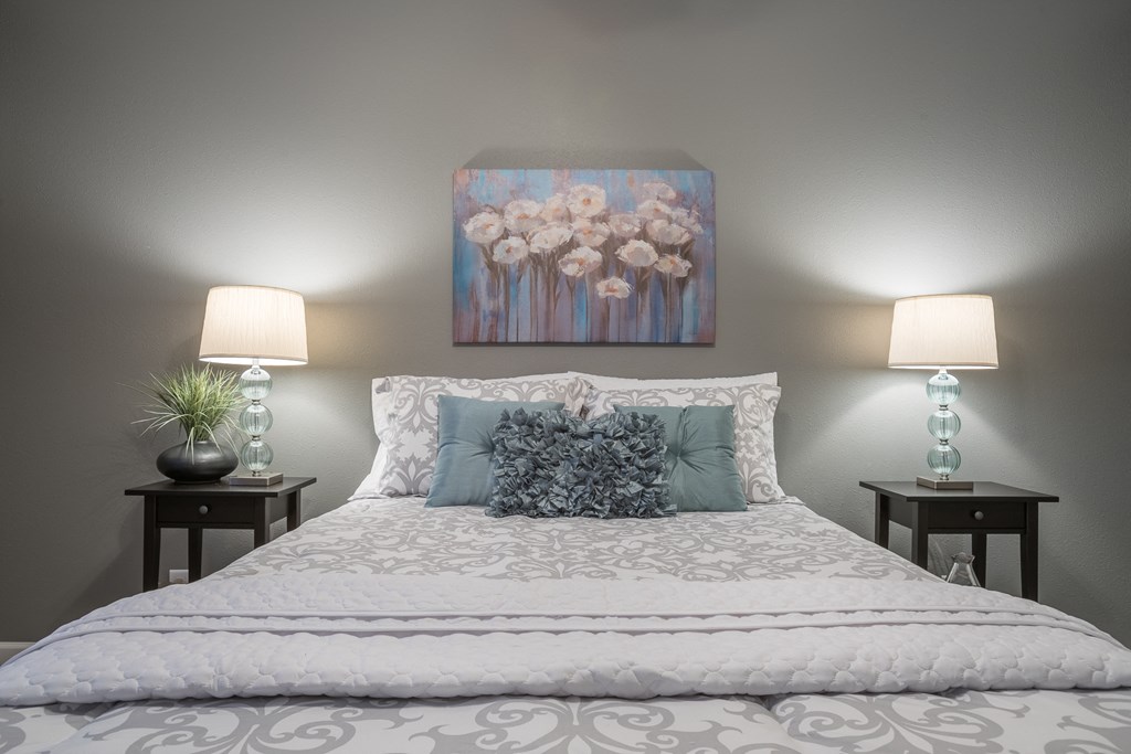 a bedroom with a bed and a painting on the wall