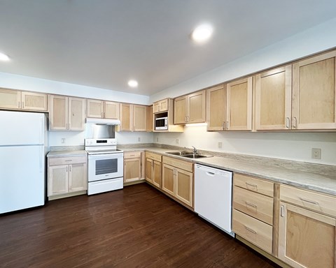 A kitchen with wooden cabinets and white appliances.