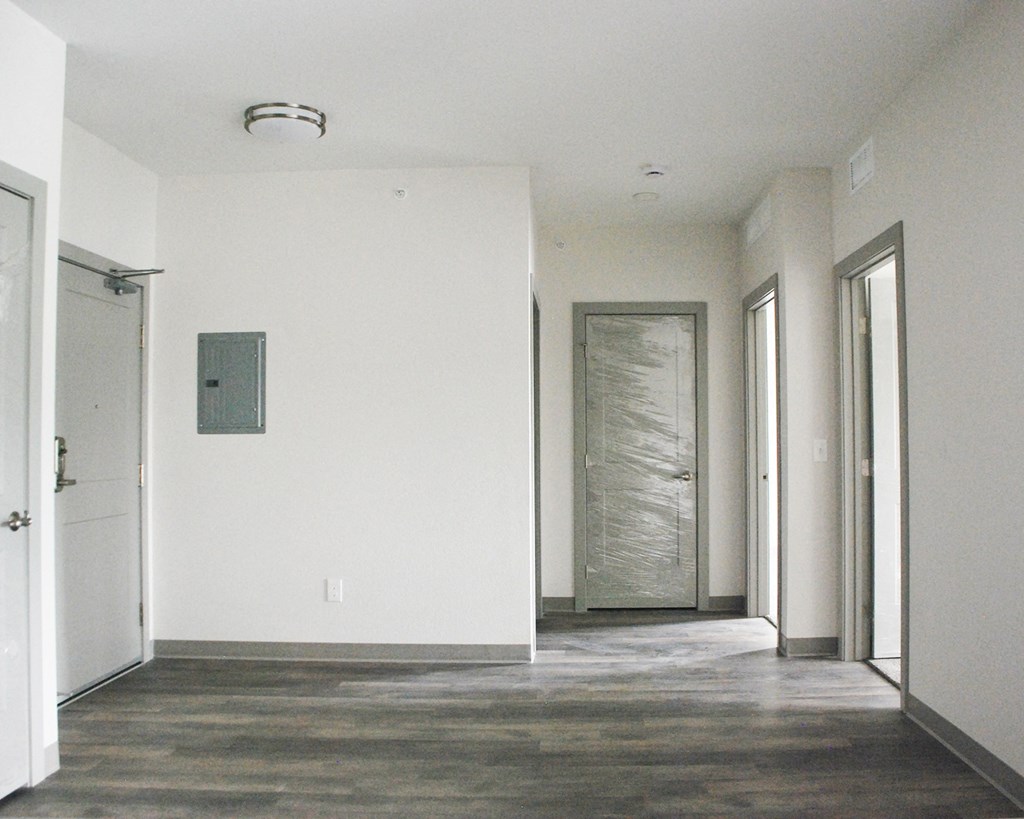 an empty hallway with white walls and a glass door