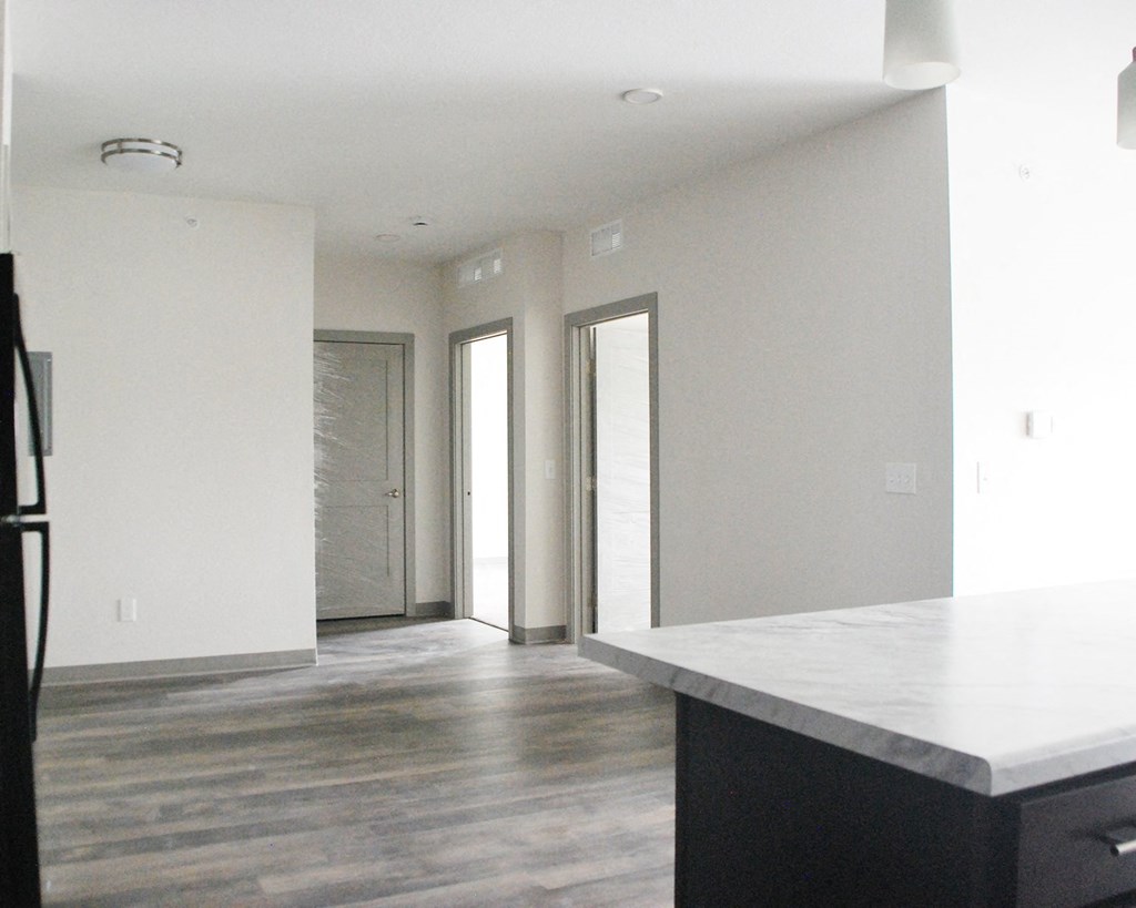 a kitchen with white walls and a white island with a marble countertop
