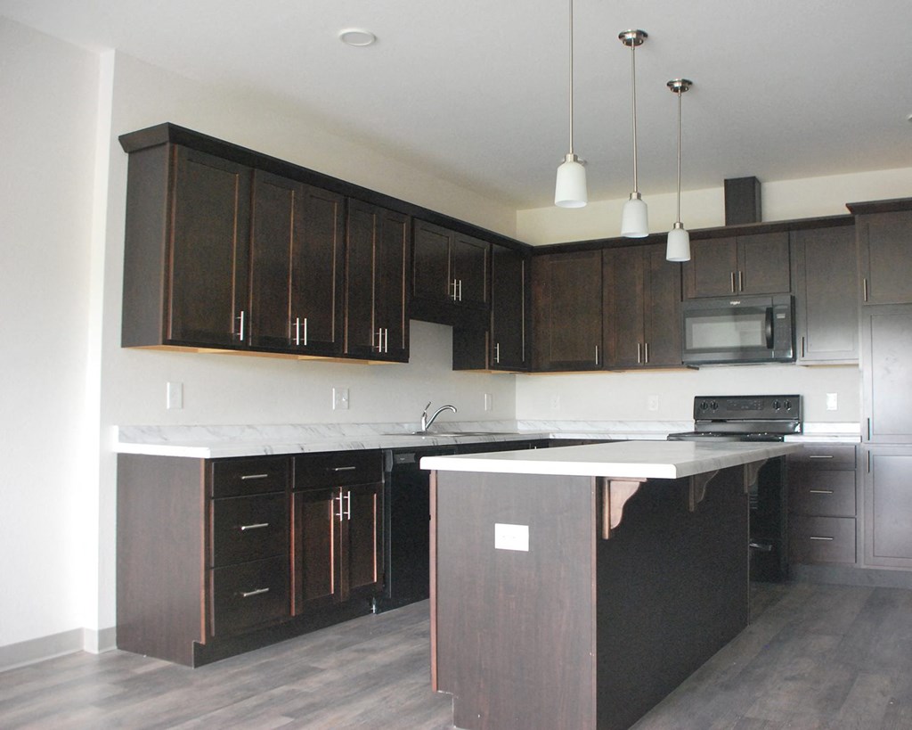 a kitchen with dark cabinets and white countertops