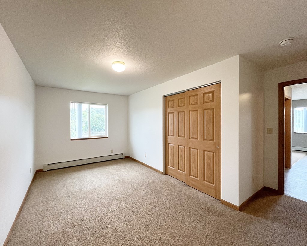 A room with a brown door and a window.