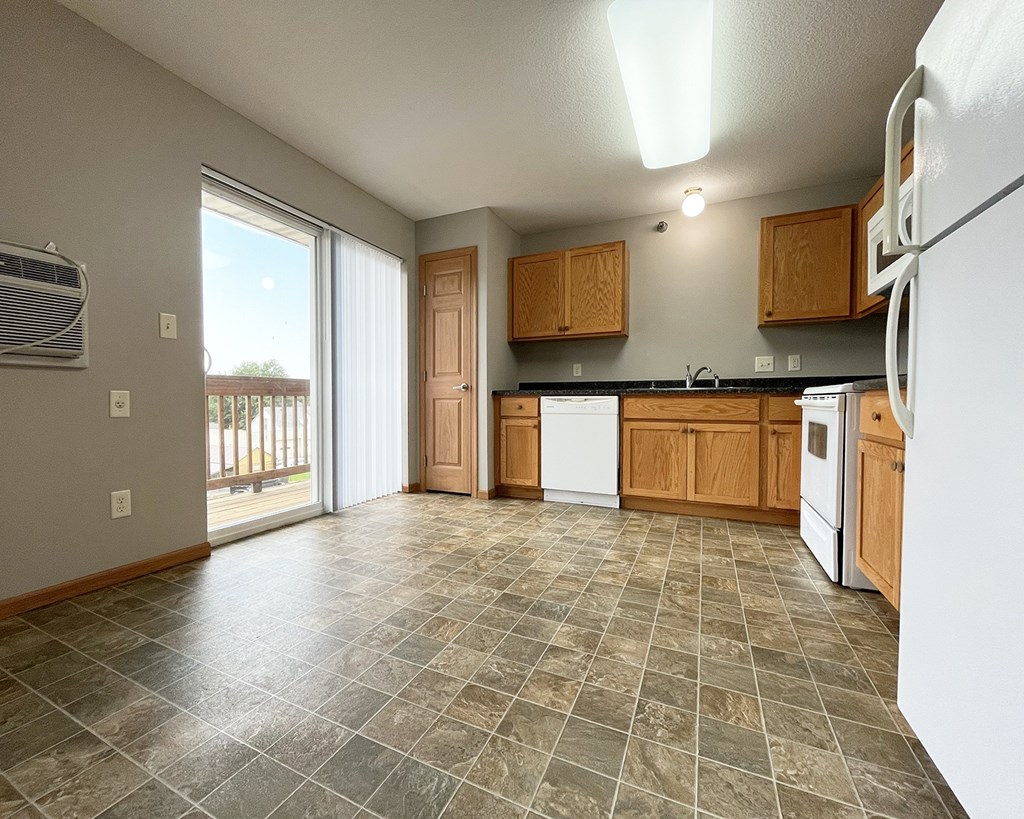 A kitchen with tile flooring and wooden cabinets.