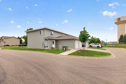 A residential area with a house, a car, and a water tower.